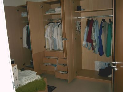 Ein gro�er Schlafzimmerschrank, ein Bett und ein Nachttisch